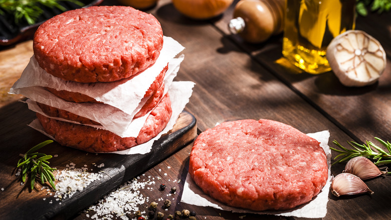 ground beef patties on wooden board