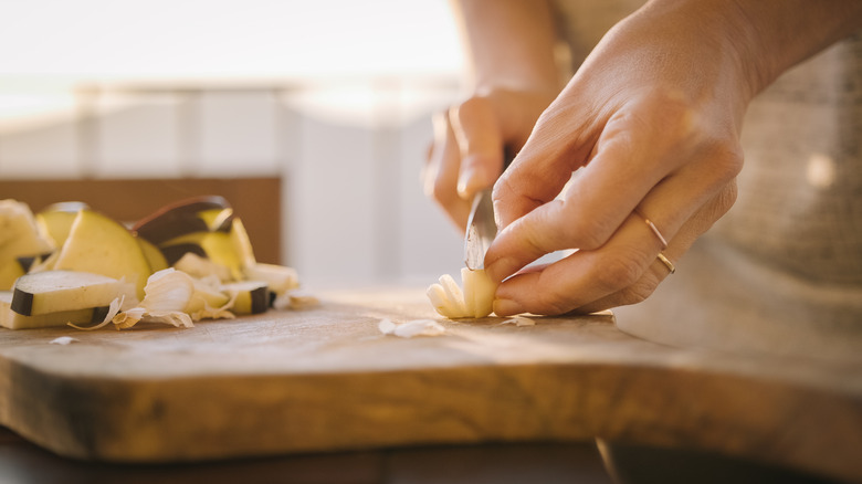 Dicing garlic, wooden cutting board