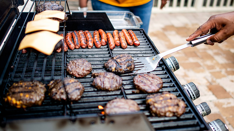 Flipping burgers on grill