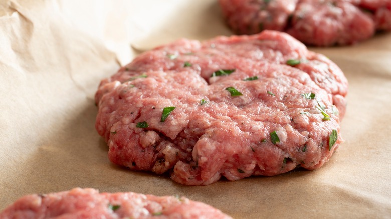 Raw burger patties on paper