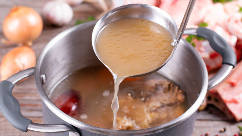 ladle full of stock from a pot