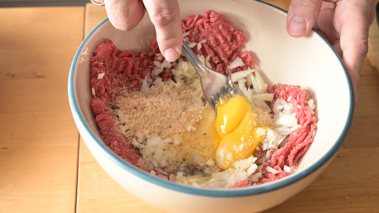 Person making meatball mixture in bowl