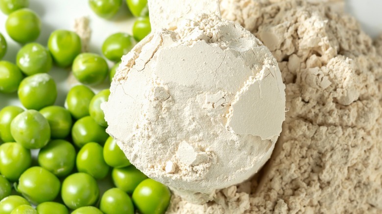 peas next to a scoop of pea protein powder