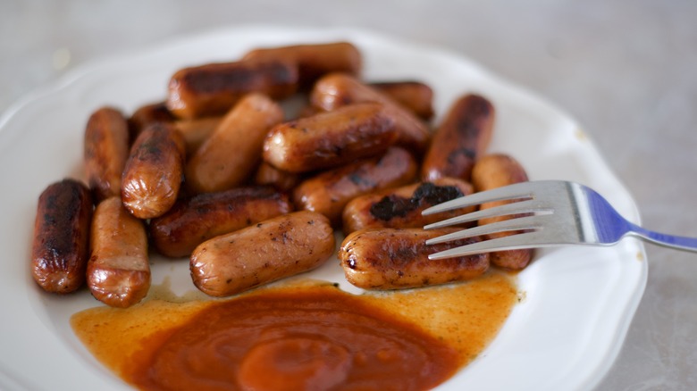 Fried Vienna sausages on white plate ketchup