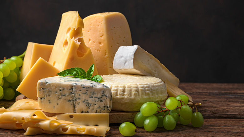 Various types of cheese on wooden board