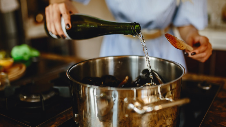 Woman pouring wine in pan