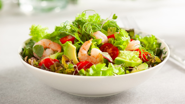 Salad with greens, tomato, avocado, and shrimp