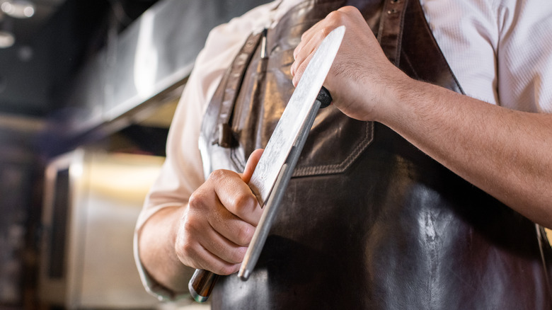 man honing a knife with a honing steel