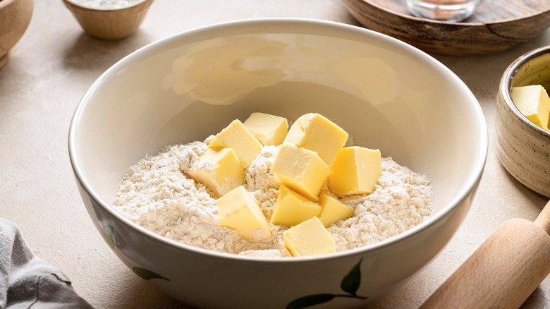 Butter cubes in a bowl of flour