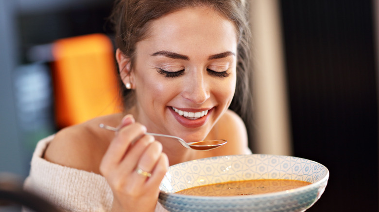 Woman eating soup with nutmeg 