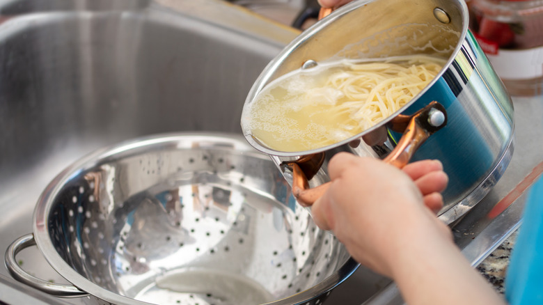 Draining spaghetti from a large pot 