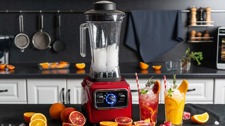 Glasses of juice beside a blender