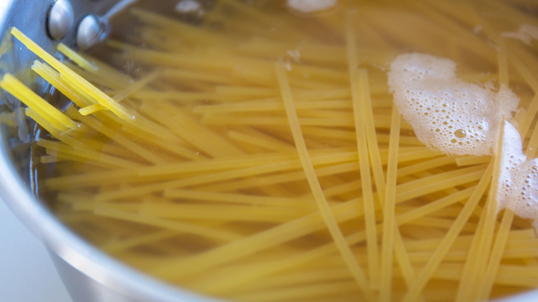 Dried spaghetti in pot of water