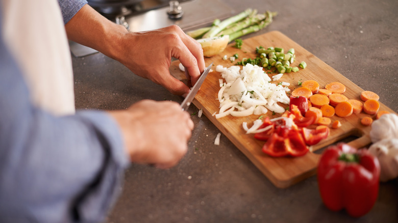 Person chopping vegetables cutting board