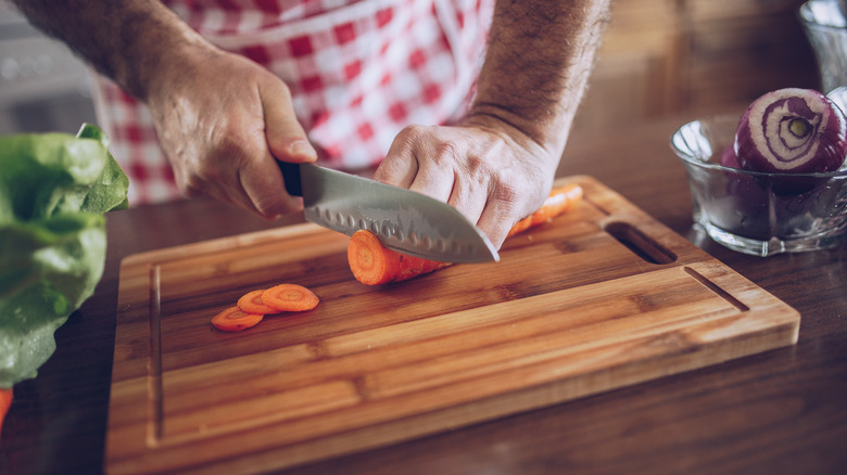 person cutting carrots 