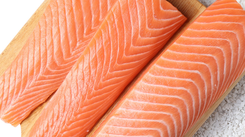 raw salmon sliced on cutting board