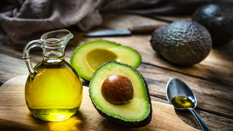 avocado oil in pitcher with cut avocado