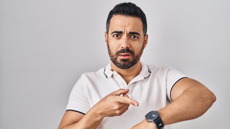 Man pointing at his watch