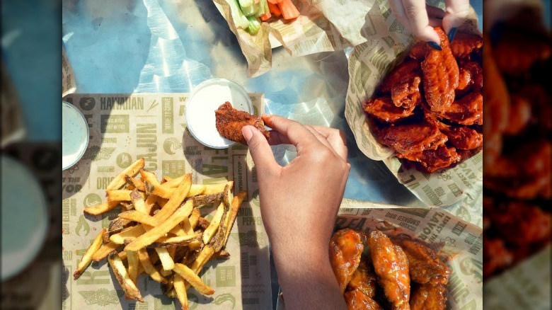 Person dunking wing in ranch