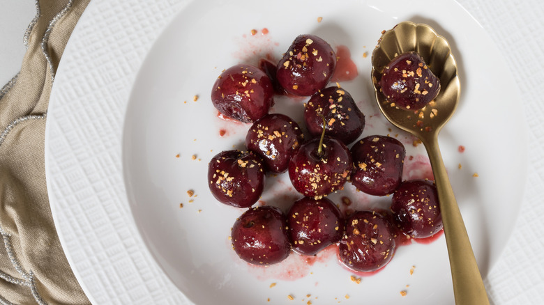 stewed cherries on plate with spoon