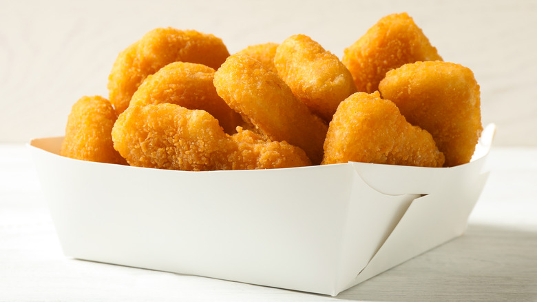 Chicken nuggets in white paper container