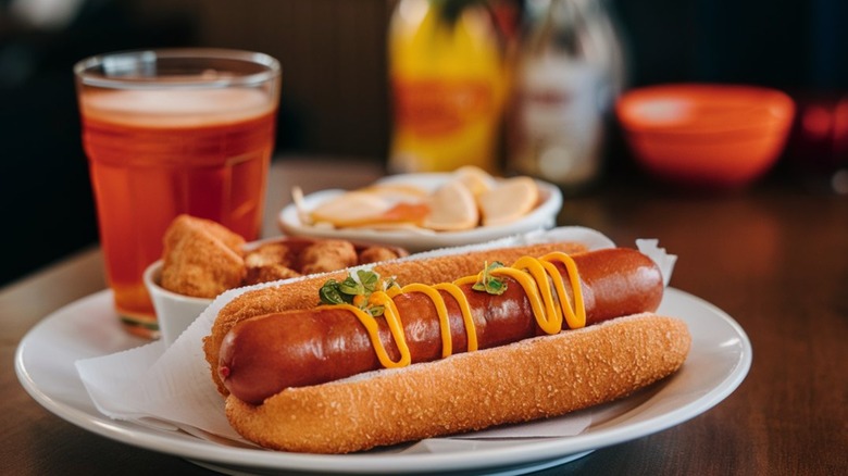 deep fried hot dog with mustard on plate