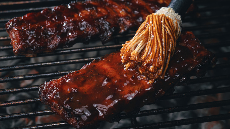 Brushing ribs with barbecue sauce