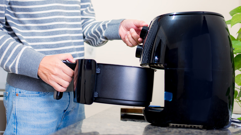 woman opening air fryer