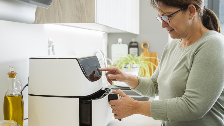 woman using air fryer