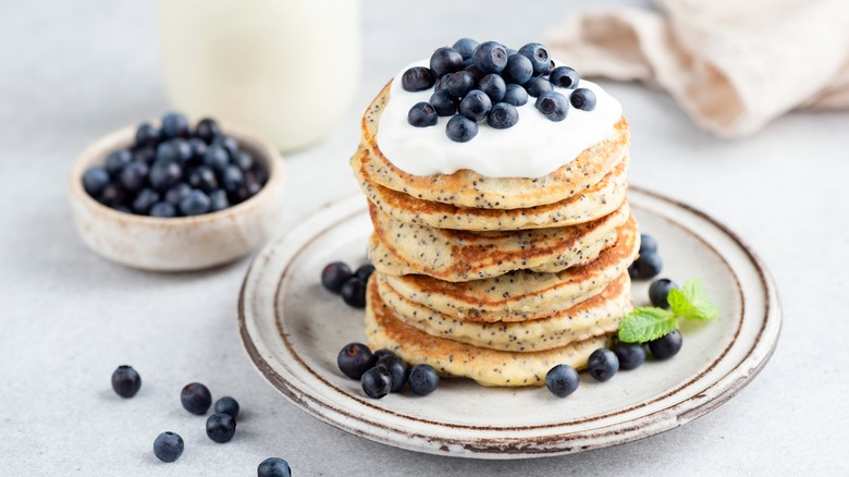 Stack of pancakes with yogurt and blueberries on a plate