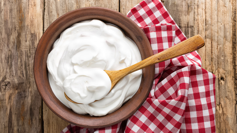 bowl of yogurt on table with wooden spoon