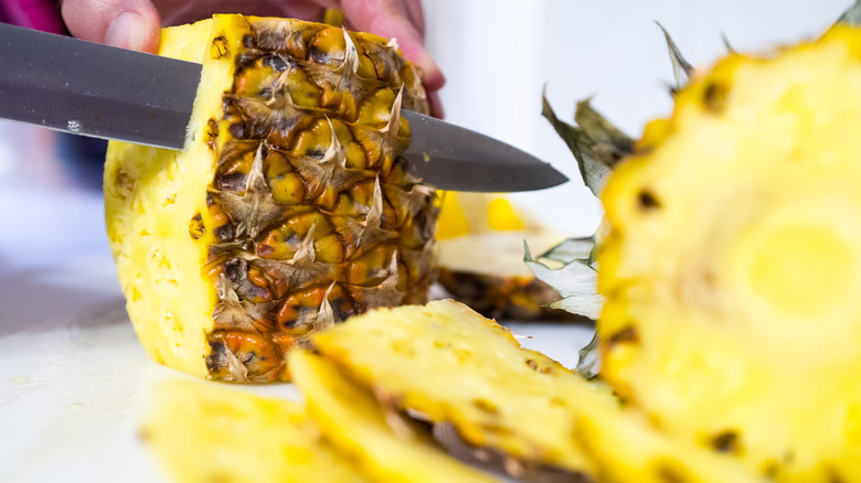 Cutting pineapple with sharp knife