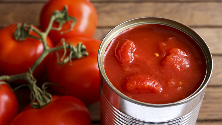 Open can of tomatoes with vine tomatoes