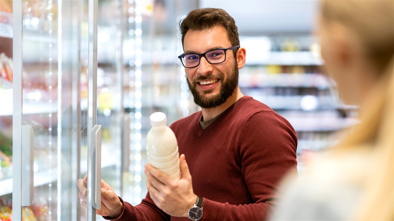 Man choosing creamer at grocery store