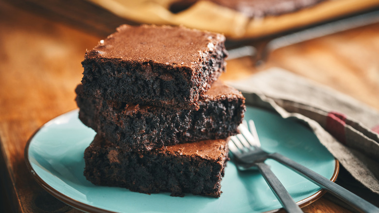 a stack of fudgy chocolate brownies on a blue plate