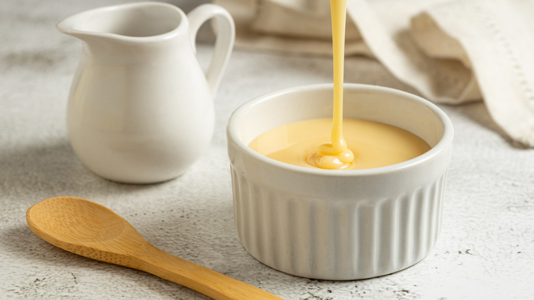 Condensed milk being poured into a ramekin