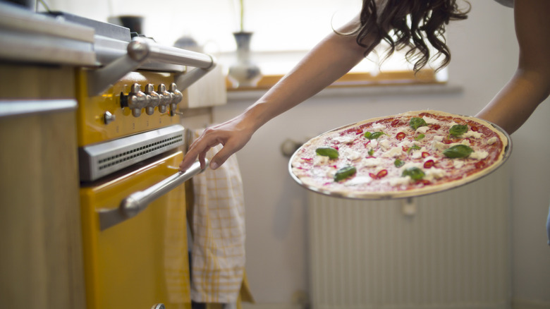 Pizza going into oven