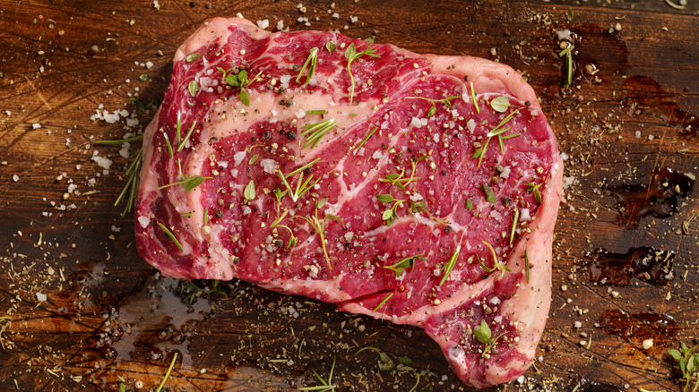 seasoned rib-eye steak on wood table