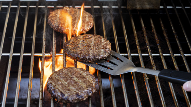 Burger patties flipped with spatula