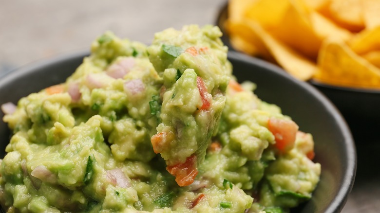 guacamole served with onions and tomatoes