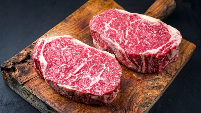 Two steaks on wooden board