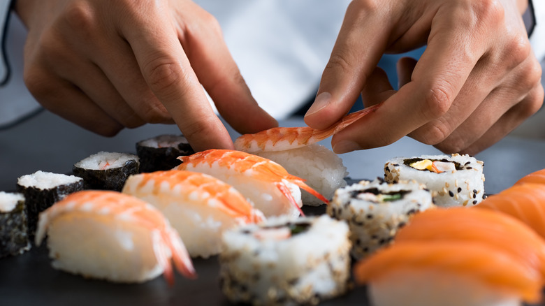 Chef carefully preparing sushi 