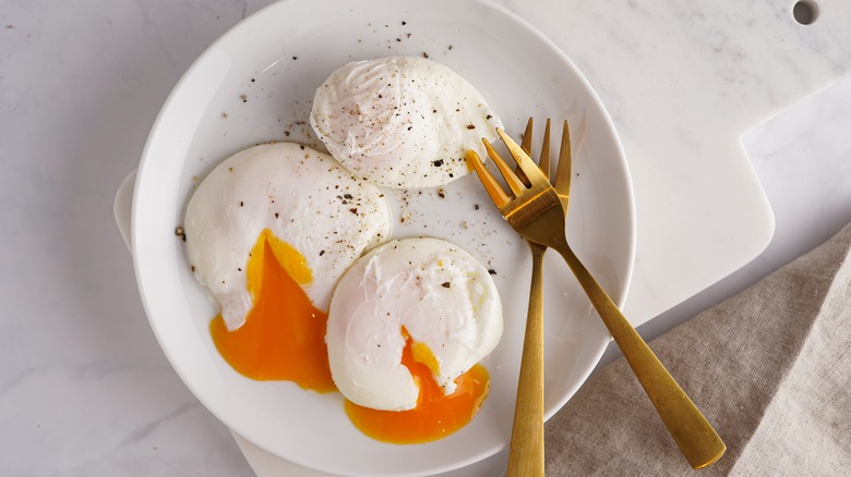 runny poached eggs on plate