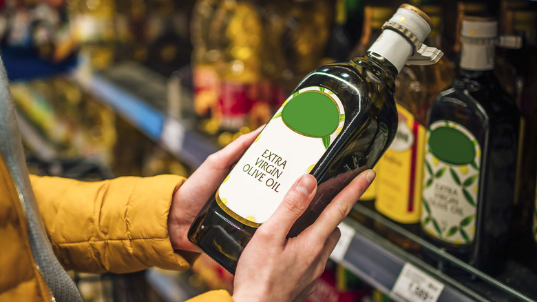 woman holding bottle of olive oil