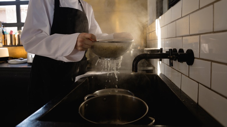 collecting pasta water in a pot