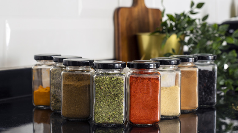 dried spices in glass jars on a kitchen counter