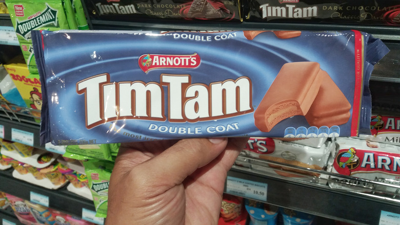 hand holding package of Tim Tams in a grocery store