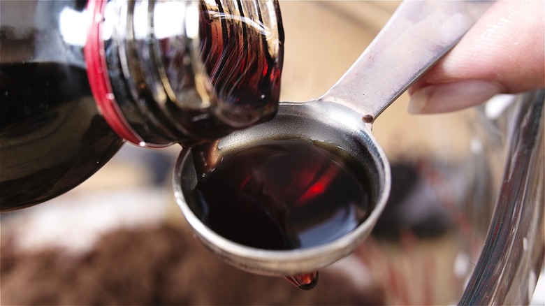 Vanilla extract poured into teaspoon