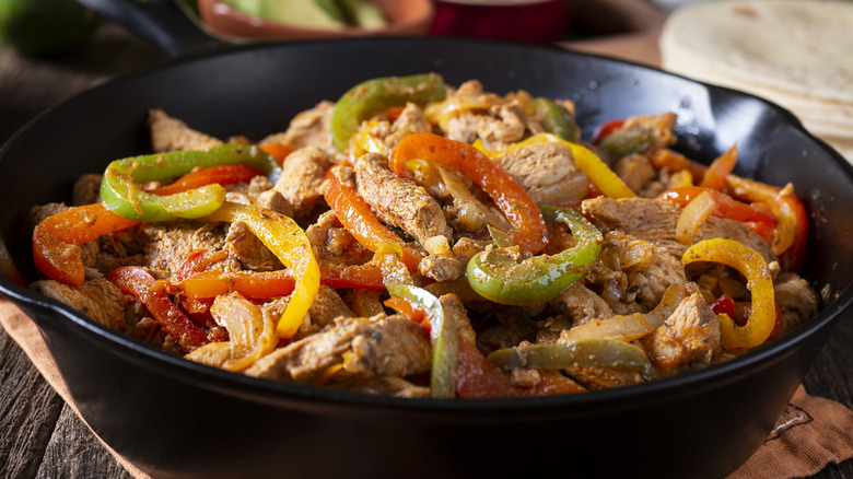 chicken fajitas with pepper in cast iron skillet