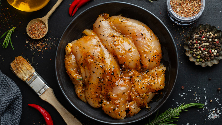 raw marinated chicken with seasoning and oil